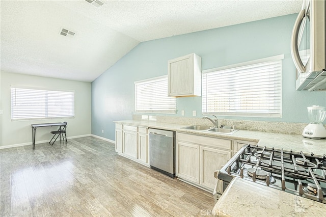 kitchen featuring visible vents, a sink, light wood-style floors, appliances with stainless steel finishes, and light countertops