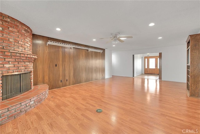 12460 Magnolia Ave, Chino, CA 91710 - unfurnished living room with recessed lighting, ceiling fan, a brick fireplace, wooden walls, and wood finished floors