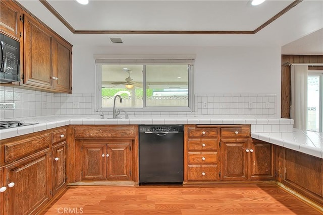 12460 Magnolia Ave, Chino, CA 91710 - kitchen featuring black appliances, a healthy amount of sunlight, light wood-type flooring, and a sink