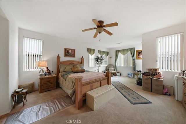 bedroom featuring multiple windows, carpet floors, and a ceiling fan