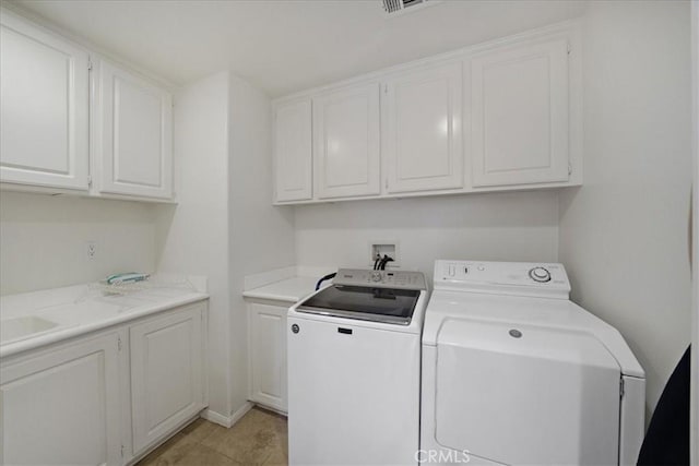 laundry area featuring cabinet space, light tile patterned floors, and separate washer and dryer