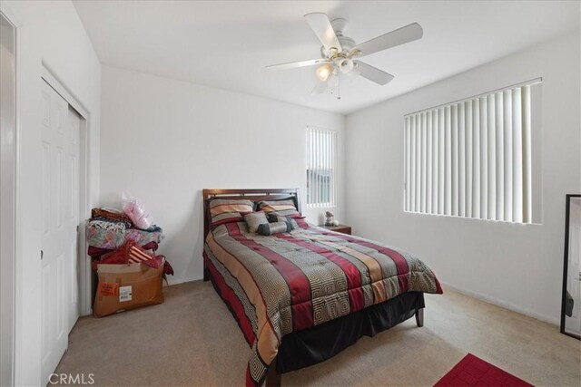 carpeted bedroom featuring a ceiling fan and a closet