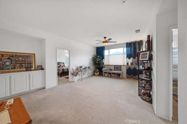 living area featuring a ceiling fan, visible vents, and carpet floors