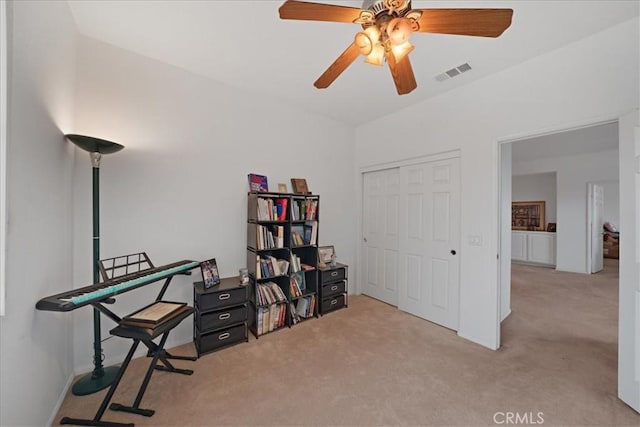 carpeted office with visible vents and a ceiling fan