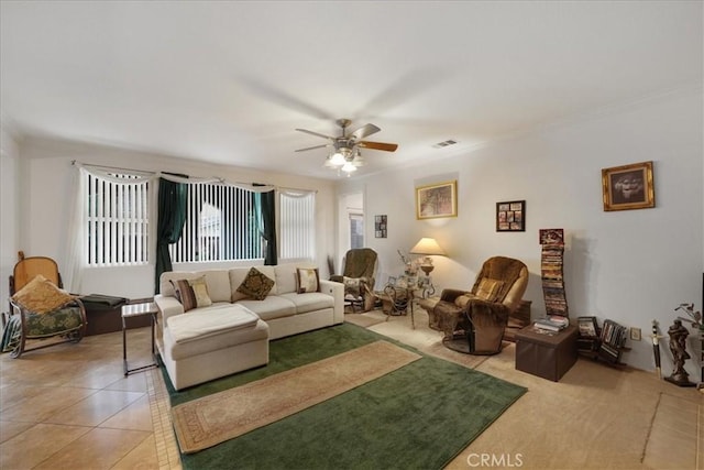 living area with light tile patterned floors, visible vents, ornamental molding, and ceiling fan