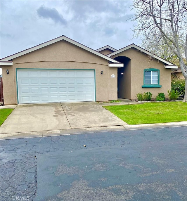 ranch-style home featuring stucco siding, a front yard, an attached garage, and driveway