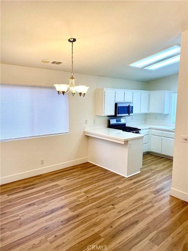 kitchen with visible vents, an inviting chandelier, appliances with stainless steel finishes, white cabinetry, and light wood-type flooring