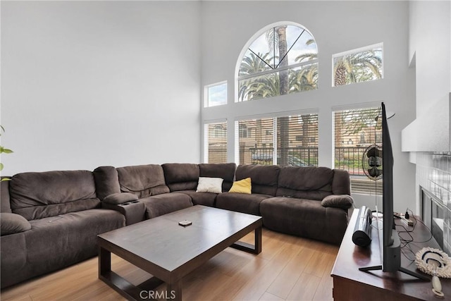 3119 Milano # J, Ontario, CA 91761 - living room featuring a high ceiling, light wood-style flooring, and a tile fireplace