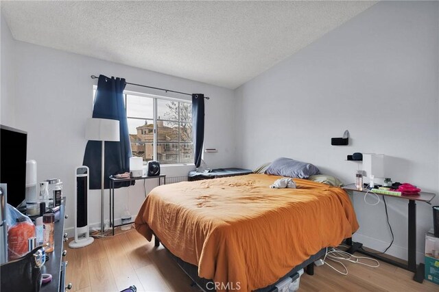 3119 Milano # J, Ontario, CA 91761 - bedroom featuring a textured ceiling, baseboards, and wood finished floors