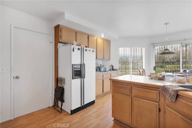 3119 Milano # J, Ontario, CA 91761 - kitchen with white fridge with ice dispenser, pendant lighting, tile counters, and light wood finished floors