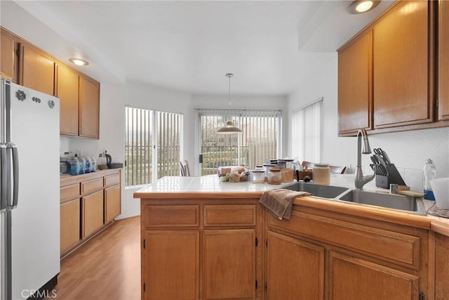 3119 Milano # J, Ontario, CA 91761 - kitchen with a sink, brown cabinets, a peninsula, and freestanding refrigerator