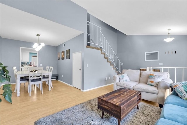 living room with a notable chandelier, stairway, baseboards, and wood finished floors