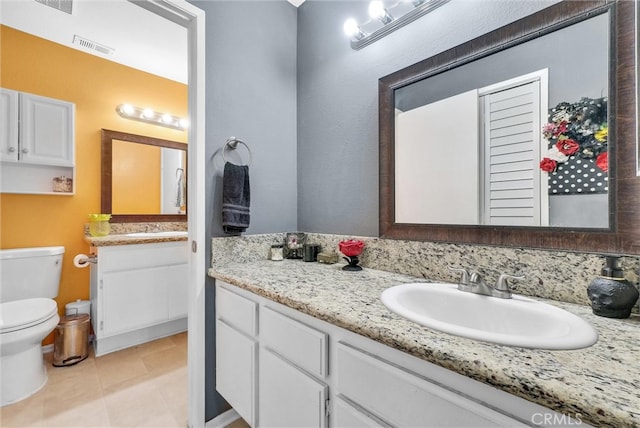 bathroom featuring visible vents, toilet, vanity, and tile patterned flooring