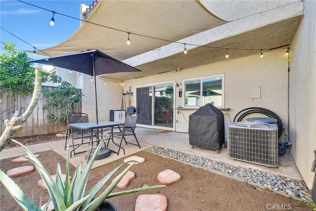 view of patio featuring central air condition unit, grilling area, outdoor dining space, and fence