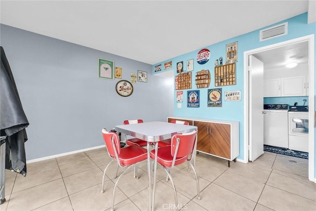 dining room featuring washer and clothes dryer, visible vents, baseboards, and light tile patterned floors