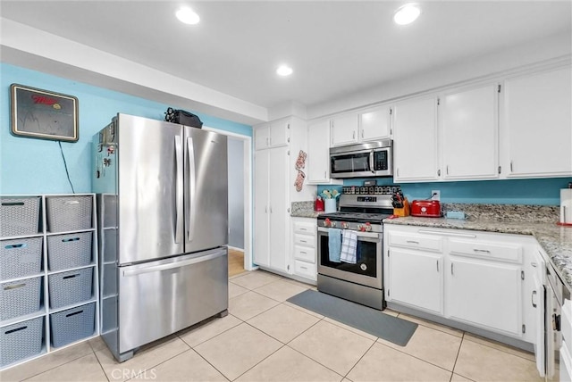 kitchen featuring white cabinetry, recessed lighting, appliances with stainless steel finishes, light tile patterned floors, and light stone countertops