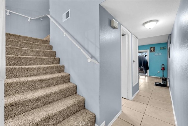 staircase with tile patterned flooring, visible vents, and baseboards