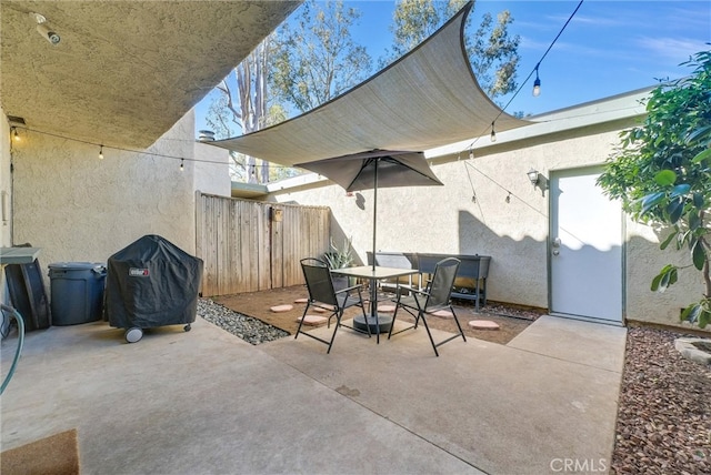 view of patio with outdoor dining area, a grill, and fence