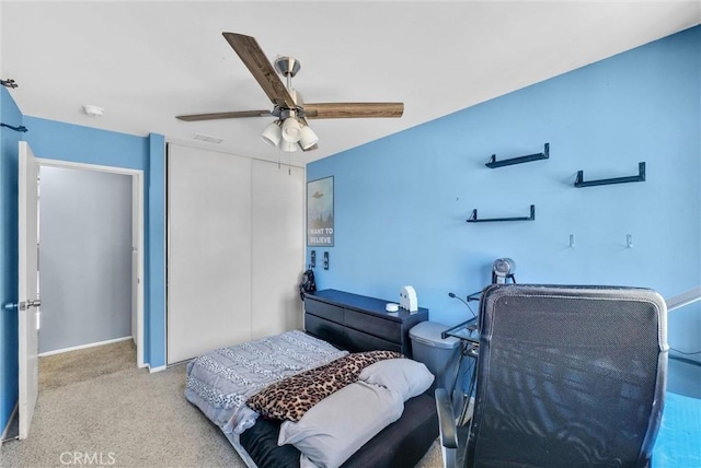 bedroom with a closet, carpet flooring, ceiling fan, and visible vents