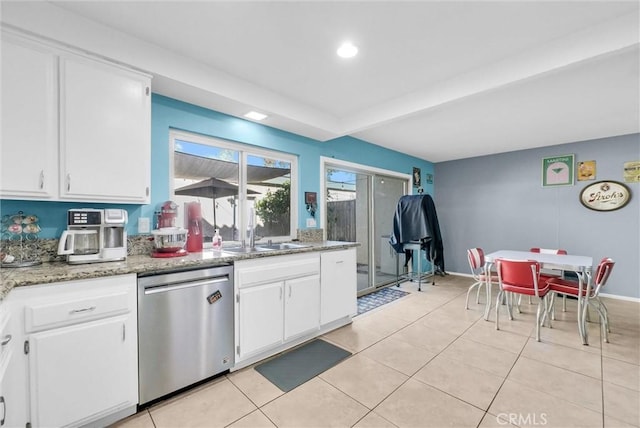 kitchen featuring dishwasher, light stone counters, light tile patterned flooring, white cabinets, and a sink