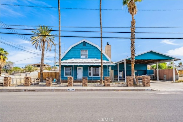 401 Cibola St, Needles, CA 92363 - view of front of property featuring a chimney, a fenced front yard, a porch, a carport, and driveway