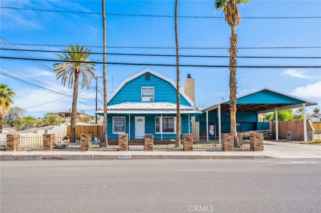 401 Cibola St, Needles, CA 92363 - view of front of house with a chimney, a fenced front yard, covered porch, a carport, and driveway