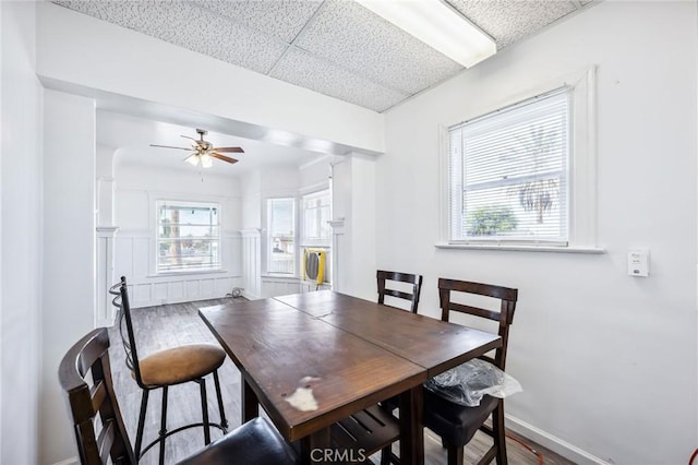 401 Cibola St, Needles, CA 92363 - dining area featuring ceiling fan, wood finished floors, and a wainscoted wall