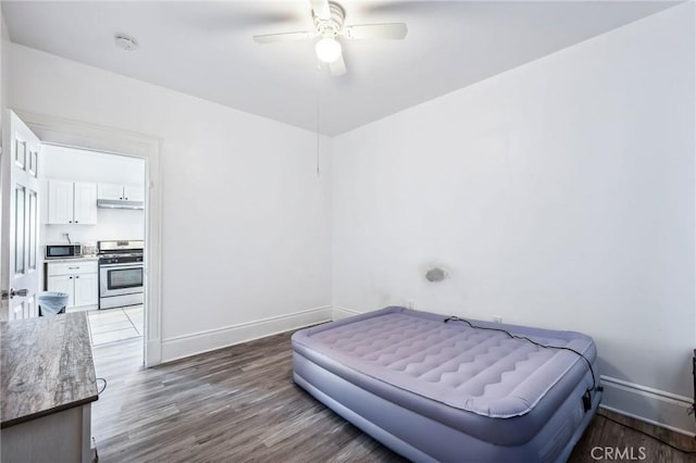 401 Cibola St, Needles, CA 92363 - bedroom featuring wood finished floors, baseboards, a ceiling fan, and ensuite bath