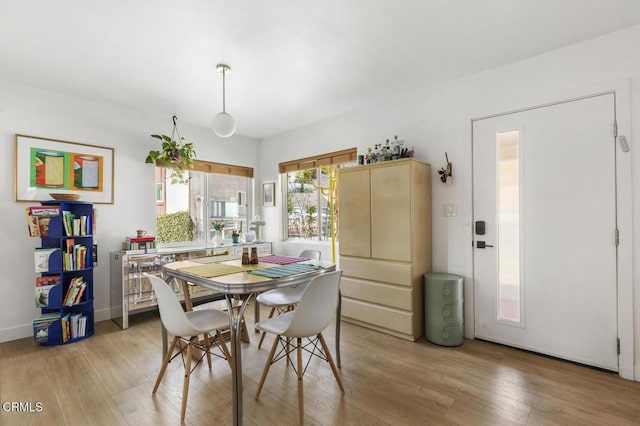 dining space with baseboards and light wood finished floors