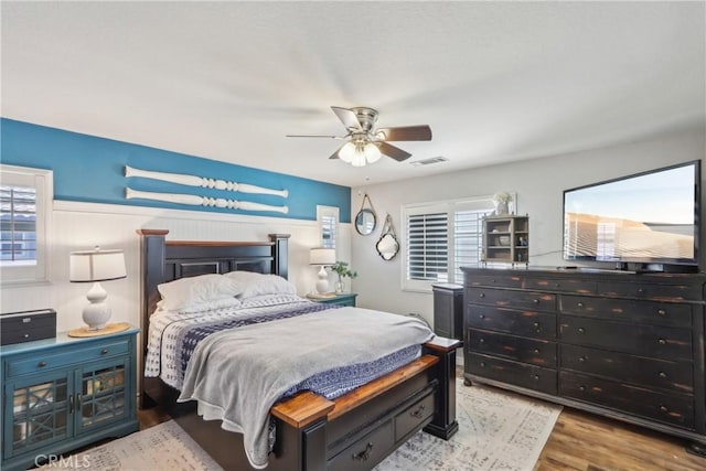 33971 Lily Rd, Yucaipa, CA 92399 - bedroom featuring wood finished floors, a wainscoted wall, and a ceiling fan