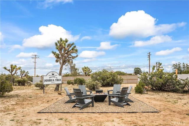 view of yard with fence and an outdoor fire pit