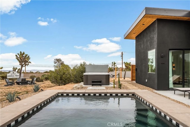 view of swimming pool with a patio area, fence, a pool, and a hot tub