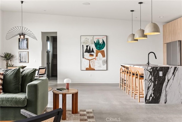 living room featuring baseboards and concrete flooring