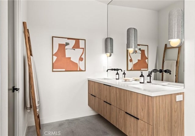 full bathroom with double vanity, baseboards, and a sink