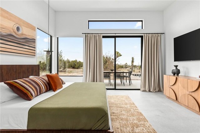 bedroom featuring access to exterior and concrete flooring