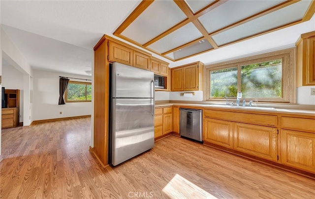 kitchen featuring a sink, light countertops, light wood-type flooring, and stainless steel appliances