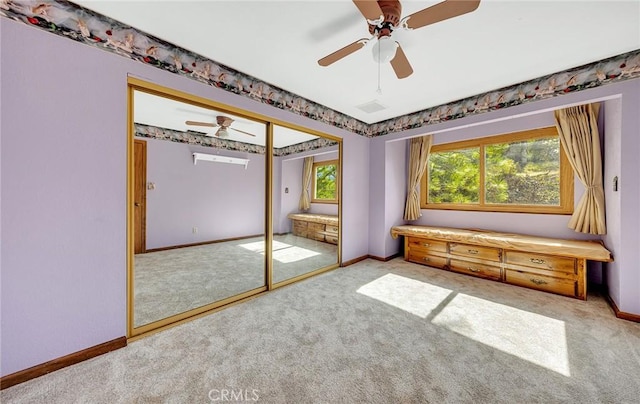 unfurnished bedroom with a closet, carpet flooring, a ceiling fan, and baseboards