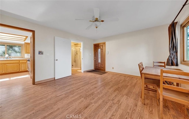 dining space featuring ceiling fan, light wood-type flooring, and baseboards