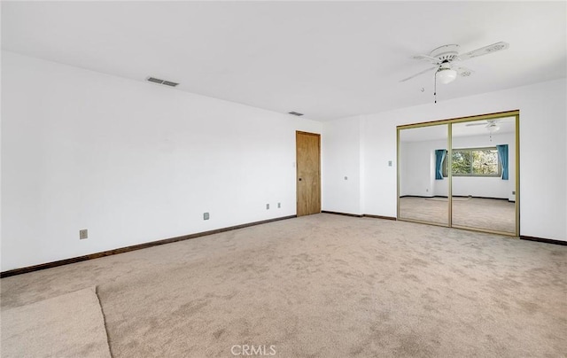 carpeted empty room featuring visible vents, baseboards, and a ceiling fan