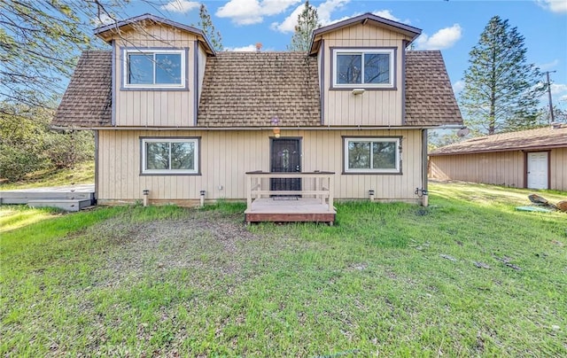 rear view of house featuring crawl space, a wooden deck, a lawn, and roof with shingles