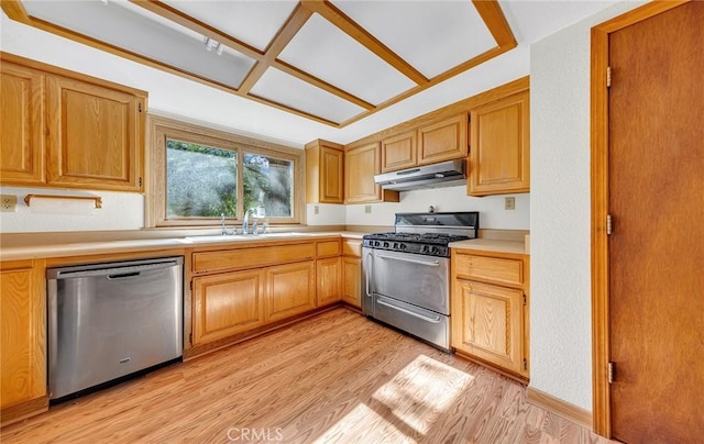 kitchen with a sink, light countertops, light wood-style floors, under cabinet range hood, and appliances with stainless steel finishes