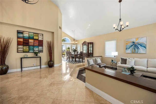 living area featuring visible vents, baseboards, high vaulted ceiling, and an inviting chandelier