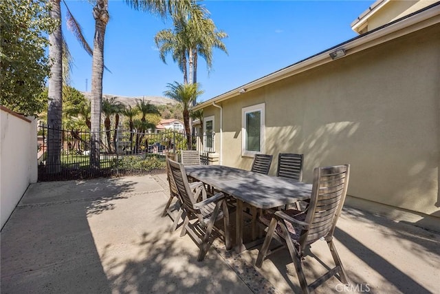 view of patio featuring outdoor dining area and fence