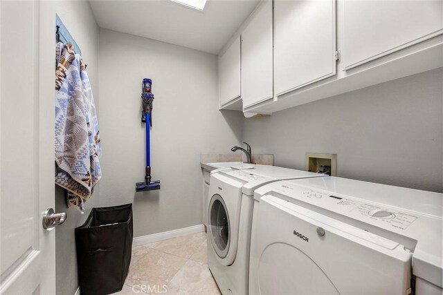 washroom featuring light tile patterned floors, cabinet space, baseboards, and washer and clothes dryer