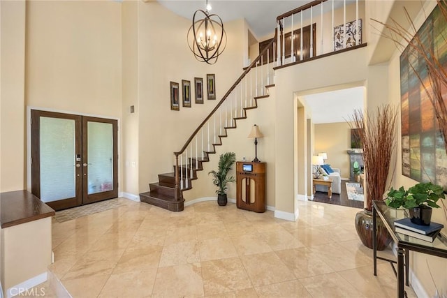 entryway with french doors, baseboards, a high ceiling, and stairway