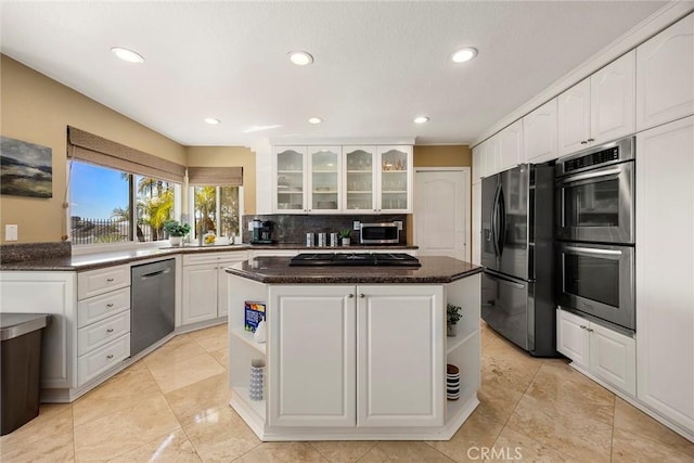 kitchen with a kitchen island, open shelves, white cabinets, appliances with stainless steel finishes, and backsplash