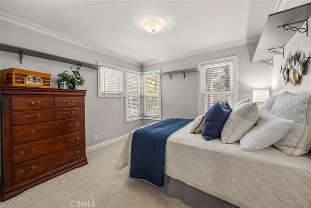 bedroom featuring light colored carpet, baseboards, and ornamental molding