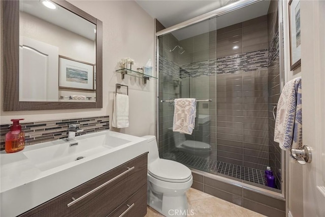 full bath featuring tasteful backsplash, tile patterned flooring, a shower stall, toilet, and vanity