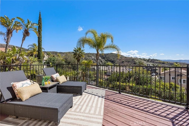 wooden deck featuring an outdoor living space and a mountain view