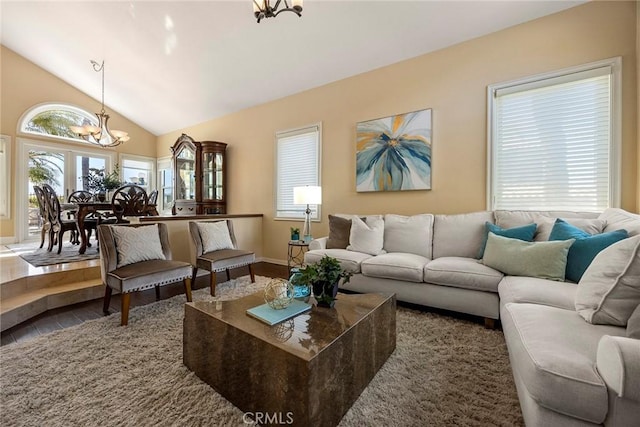 living area featuring a chandelier and high vaulted ceiling